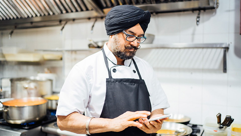 A chef using his smartphone for UPS tracking support.