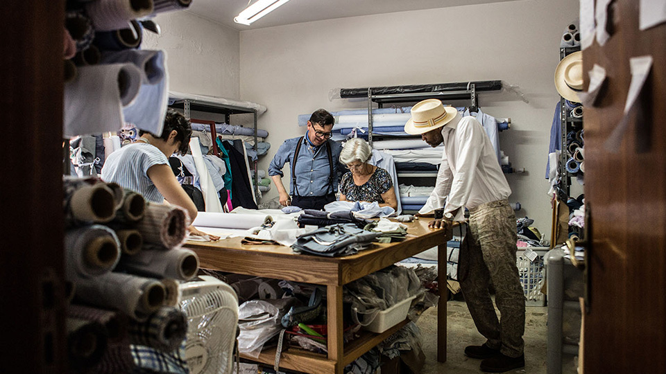 Several employees in a garment making room.