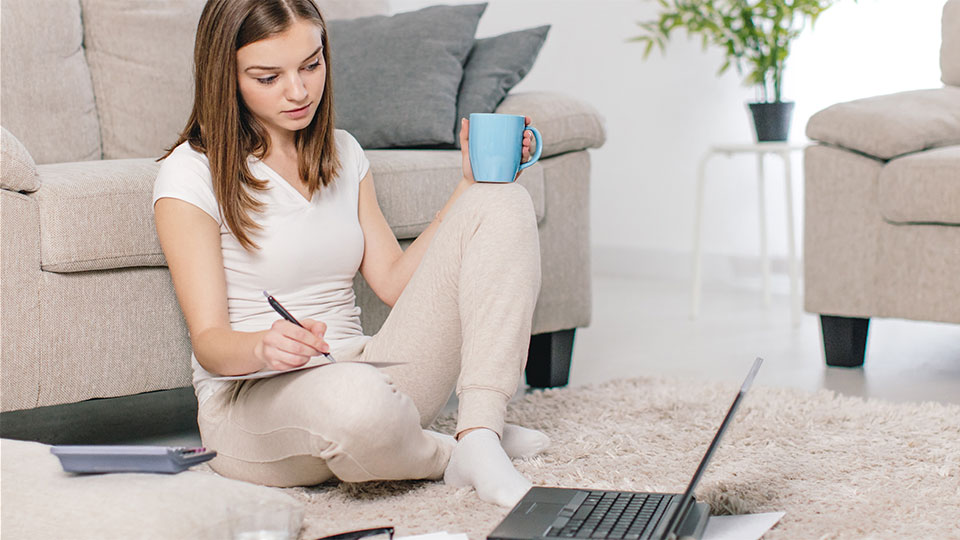 Mujer sentada con una computadora portátil y papel